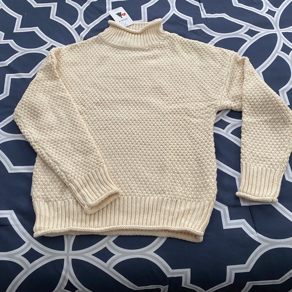 Cream mock neck cable knit sweater.